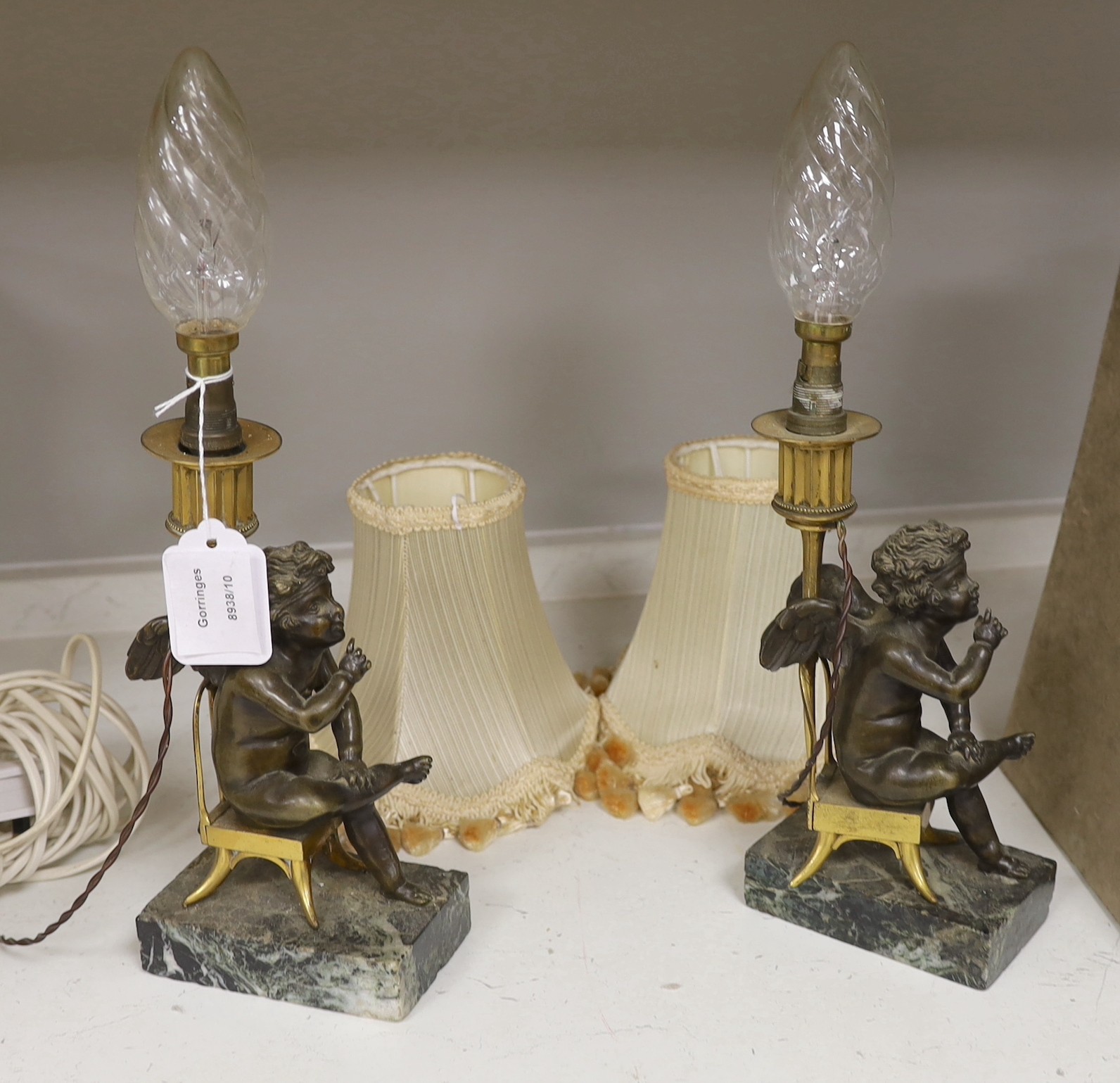 A pair of late 19th century figural bronze and ormolu cherub candlesticks, converted to lamps, 26cm tall excluding bulb